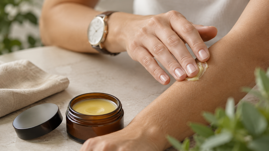 Hand applying CBD balm to the forearm with an open balm tin nearby